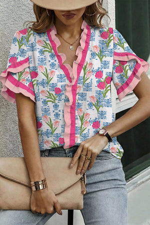 Floral ruffle v-neck tunic shirt with pink trim and tiered sleeves.