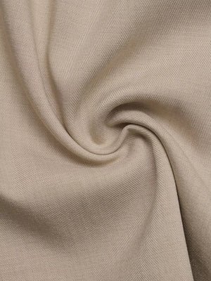Close-up of beige fabric texture with subtle ribbing.