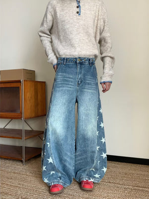 Men's blue wide leg jeans with star print and distressed wash.