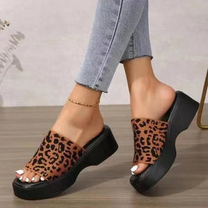 Platform knit slide sandals in leopard print with black soles and a thick sole.