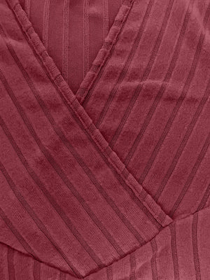 Plunging ribbed wrap top in rust with vertical stripe texture and crossover detail.