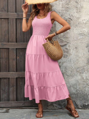 Pink smocked bodice tiered maxi dress with square neckline and sleeveless cut.