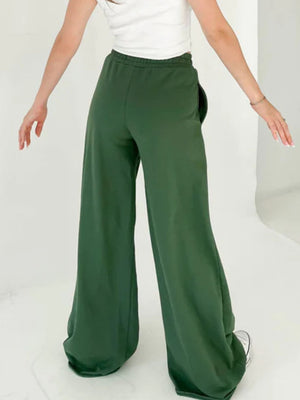 Dark green wide-leg lounge pants with pockets and a relaxed fit.