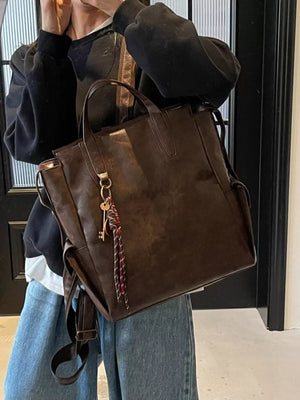 Convertible leather backpack in coffee brown with key charm detail