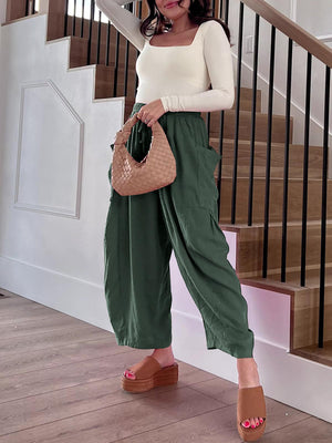 Dark green linen balloon trousers with cargo pockets and a drawstring waist.
