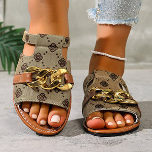Patterned slide sandals in apricot with gold chain accent and brown trim.