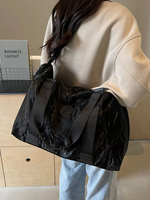 Black Oxford cloth travel bag with textured finish and dual straps
