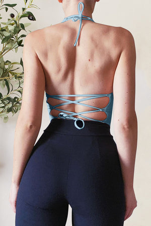 Sky blue halter crop top with lace-up back detail.