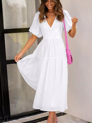 White midi dress with puff sleeves, V-neck, elastic waist, and tiered skirt.