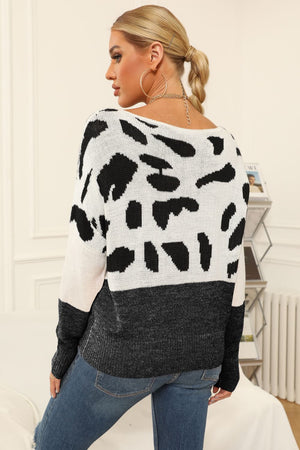 Cow print acrylic knit sweater with boat neck and colorblock detail.