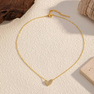 Gold necklace with a delicate rhinestone heart pendant.