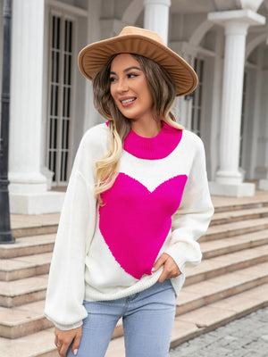 White acrylic sweater with a large pink heart intarsia and pink neckline.