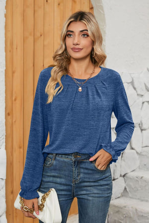 Blue knit top with pleated yoke and ruffled cuffs, crew neck, long sleeves.