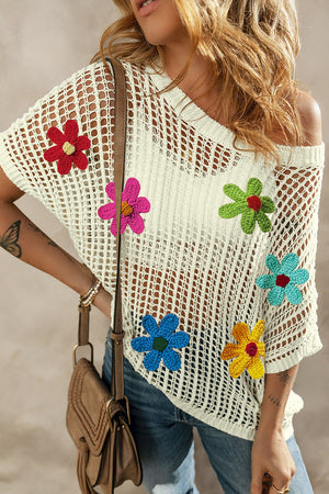 White crochet mesh overlay top with colorful floral appliques and short sleeves.