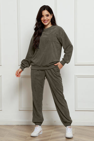Corduroy lounge set in dark gray with crewneck sweatshirt and pocket detail, and matching pants.