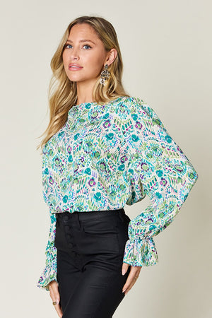 Painterly print blouse in sky blue with gathered long sleeves and a mock neckline.