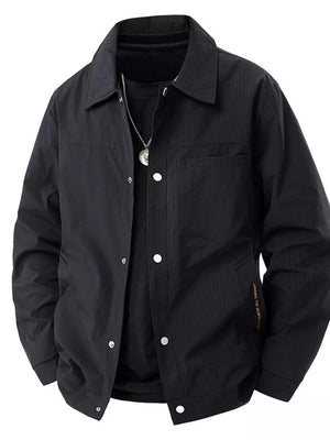 Black snap-down jacket with subtle vertical stripe texture and chest pocket.