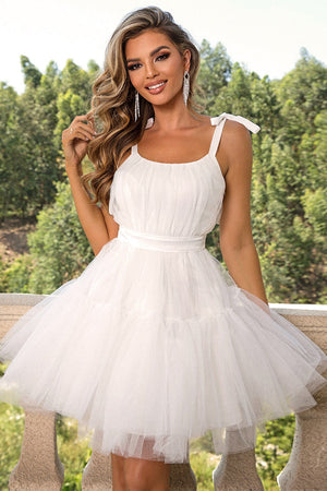 White tulle tiered mini dress with bow straps and a cinched waist.