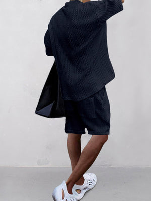 Navy blue cable-knit two-piece set with shorts and a short-sleeve V-neck top.