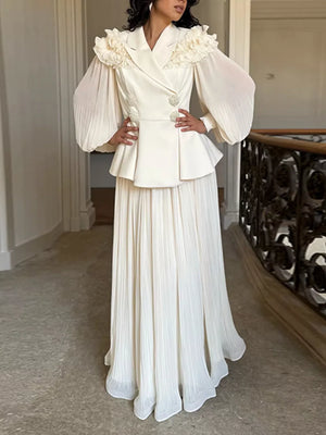 Apricot skirt suit with ruffled collar, peplum jacket, and pleated maxi skirt.