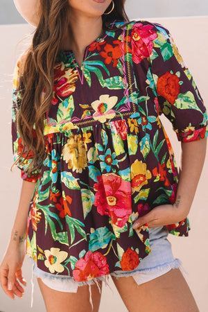 Embroidered floral babydoll blouse with split neck and puff sleeves.