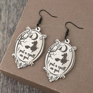 Black wood drop earrings with witch and moon design, saying I put a spell on you