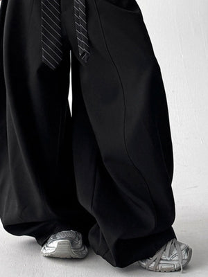 Men's black wide leg sweatpants with drawstring and striped tie detail.