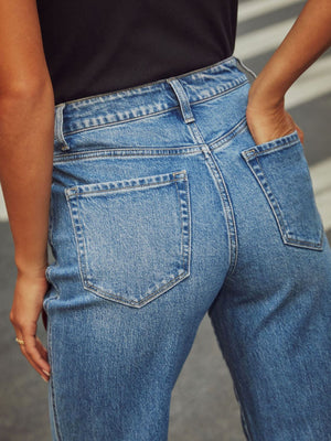 Light wash denim jeans with cuffed hemline, wide-leg cut, and visible back pockets.