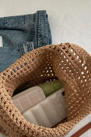 Camel crochet weave shoulder bag with open knit detail, holding a wallet and phone.