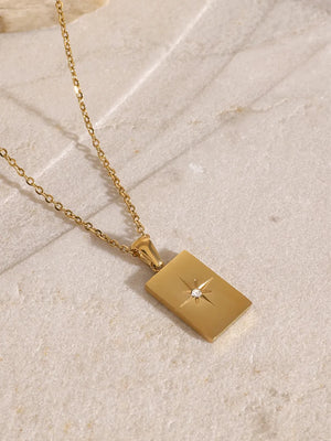 Gold layered chain necklace with rectangular celestial pendant and diamond accent