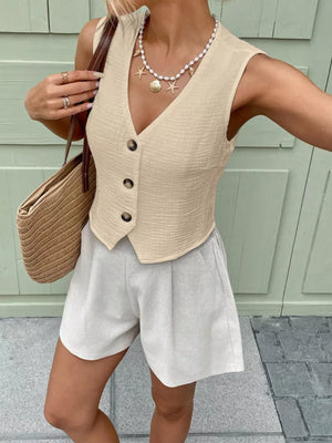 Apricot textured button vest with V-neck and button front, cropped length.