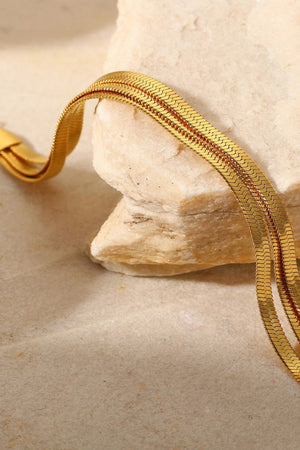 Gold triple herringbone chain bracelet with a flat, sleek design.