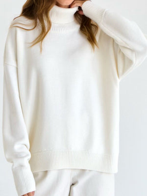 Ivory relaxed turtleneck sweater with sculptural sleeves and ribbed cuffs and hem.