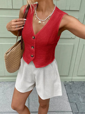 Red textured button vest with V-neck and cropped length, styled with shorts.