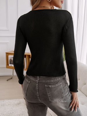 Black knit cropped cardigan with long sleeves and a keyhole detail.