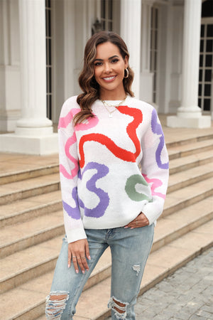 White crewneck sweater with abstract swirl pattern in pink, red, purple, and green.