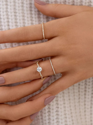 Gold twisted pavé zircon engagement ring with a thin band ring.