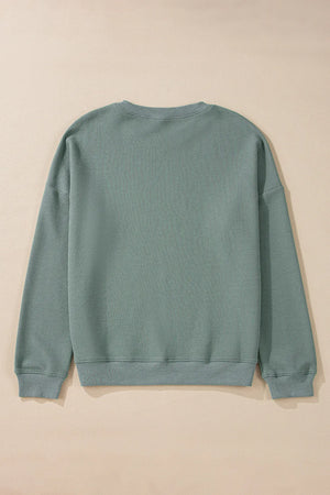 Relaxed crewneck sweater in sage waffle knit cotton with long sleeves and ribbed cuffs and hem.
