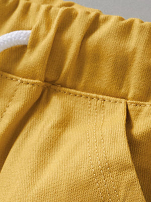 Yellow cotton toddler shorts with drawstring waist and stitched pockets.