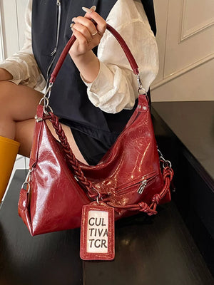 Red shoulder bag with braided strap and vintage-inspired details