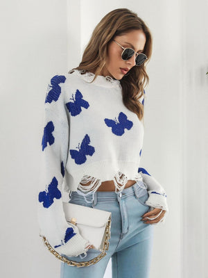 White cropped knit sweater with blue distressed butterfly print and frayed hem.