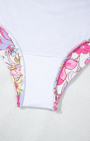Floral ruffle backless swimsuit in fuchsia pink with a white lining and floral print trim.