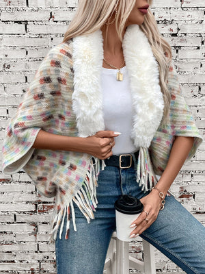 Textured plaid acrylic poncho with faux fur collar and fringe details.
