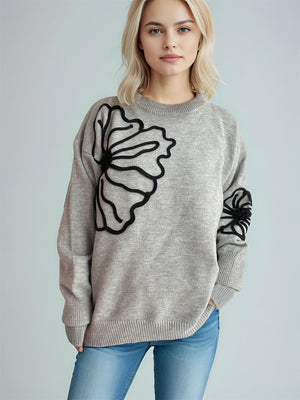 Gray knit sweater with black floral applique on chest and sleeve, crew neck, long sleeves.