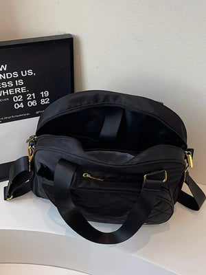 Black quilted Oxford bag with adjustable strap and gold hardware.