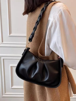 Black ruched crossbody bag with braided strap detail.