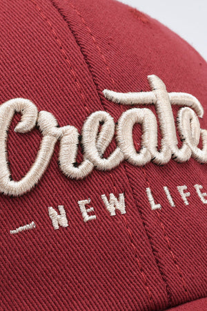 Deep Red baseball cap with embroidered "Create New Life" text