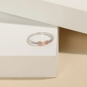 Infinity knot ring with pink stones and rose gold detail on silver band
