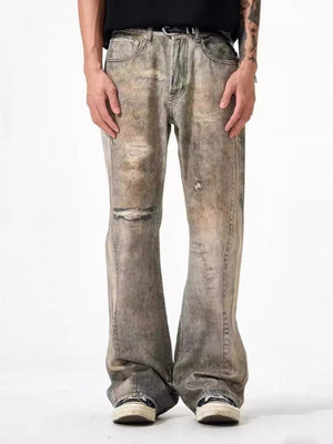 Men's loose-fit jeans in grey washed cotton with heavy distressing and rips.