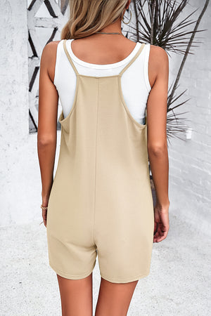 Khaki relaxed romper with patch pockets and spaghetti straps, worn over a white tank top.
